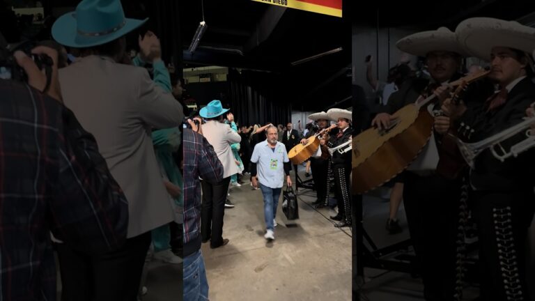 Mariachi band playing, crowd cheering, and fans showing love.