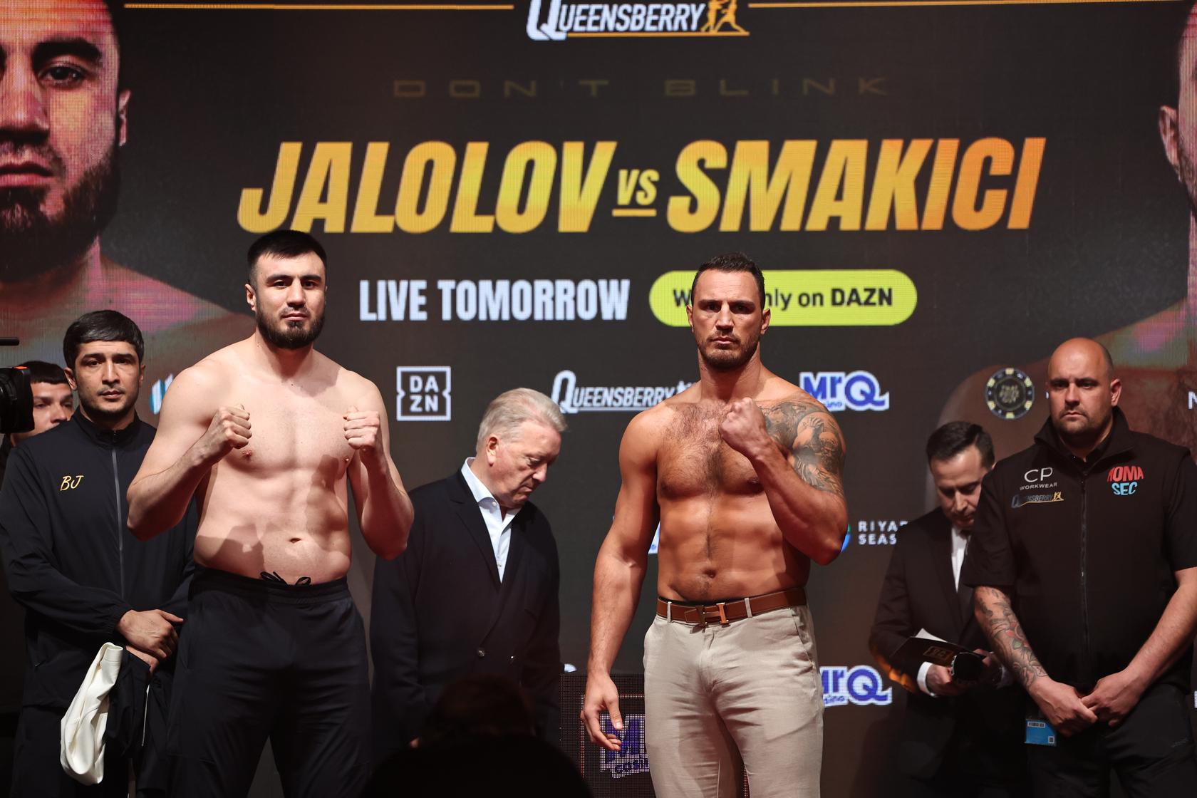 Bakhodir Jalolov and Agron Smakici pose on stage during the official heavyweight weigh-ins